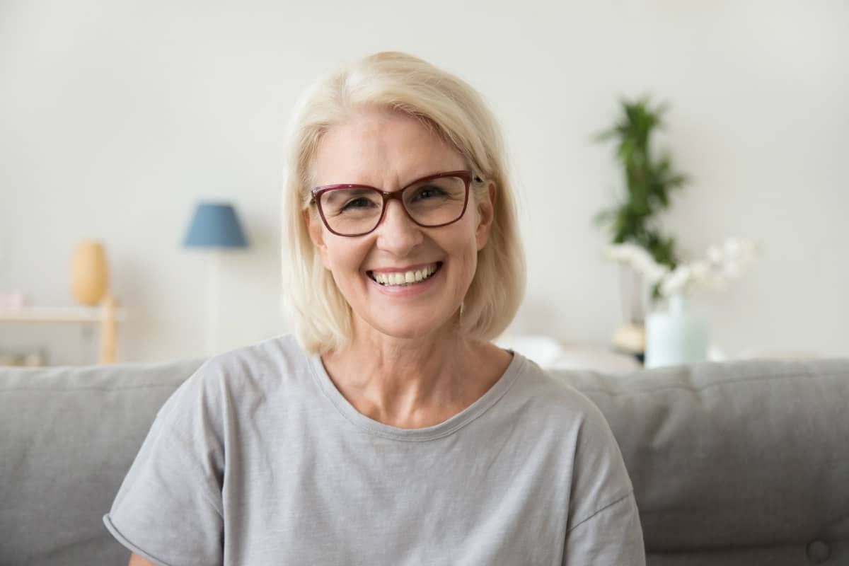 elderly lady sitting on a sofa smiling