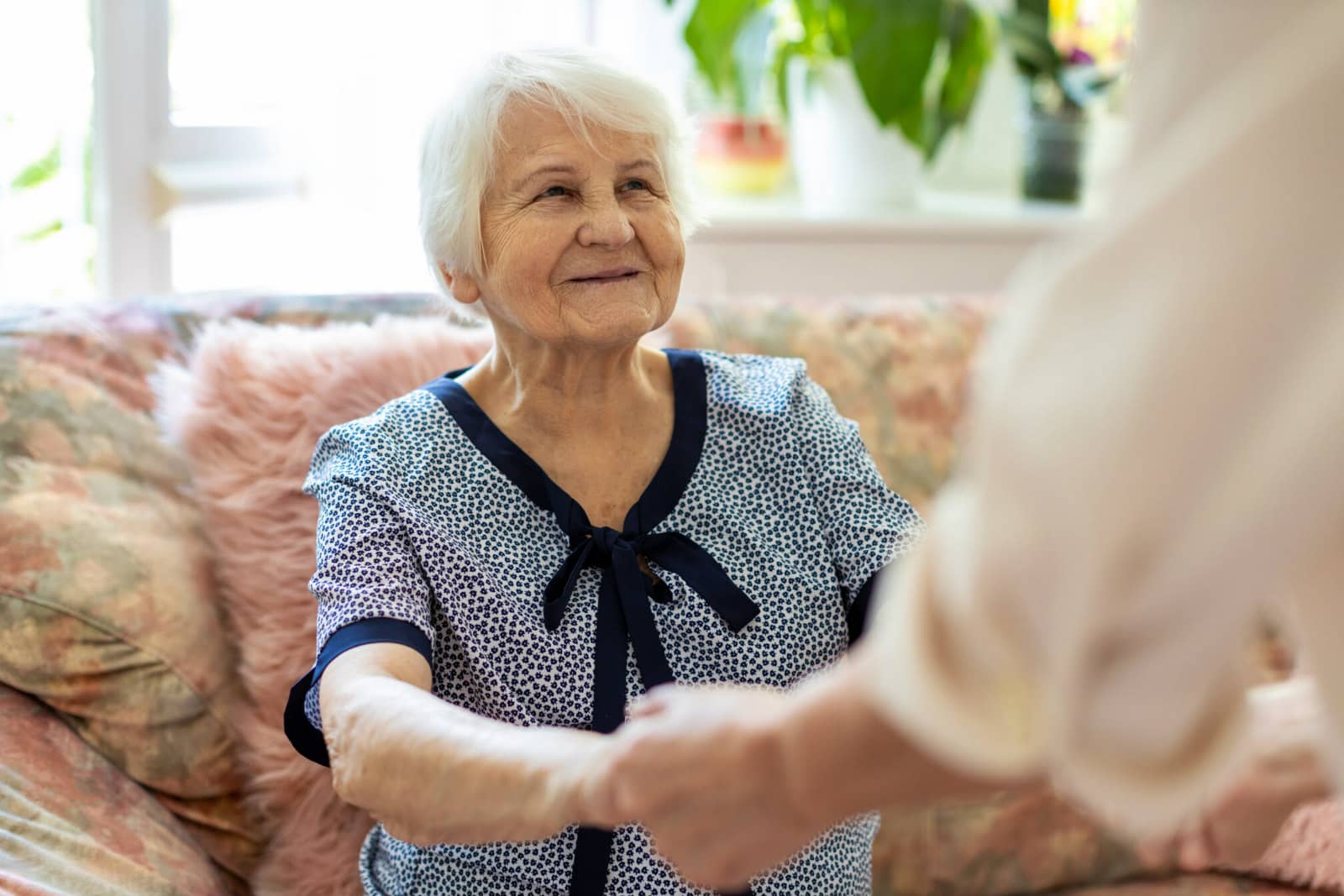 elderly lady being helped up out of her seat