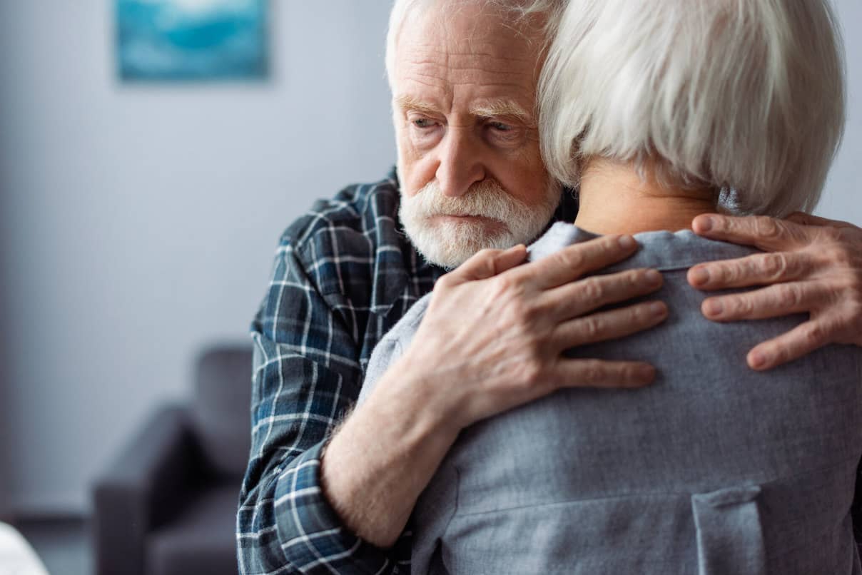 elderly man with dementiai hugging a lady